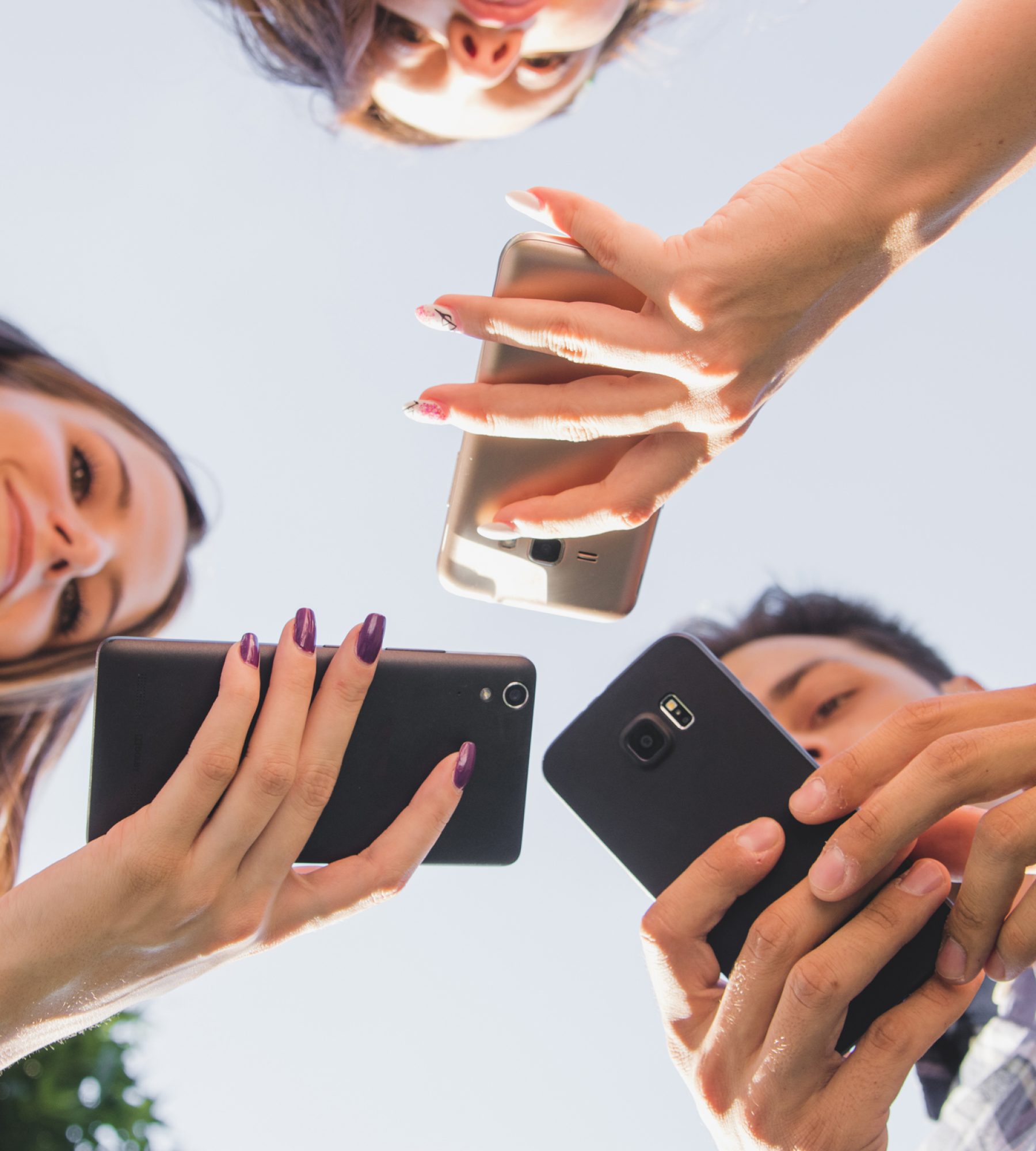 from-below-view-of-teens-with-smartphones